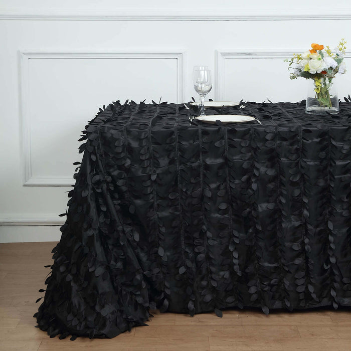 Black leaf-pattern tablecloth draped elegantly over a table in a styled setting.