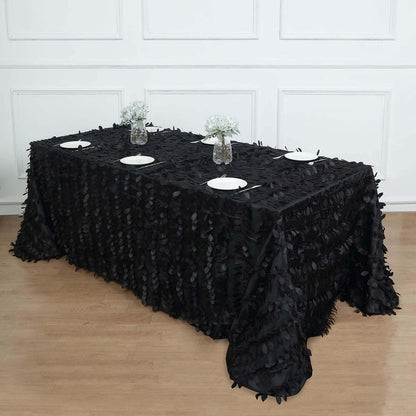 Black ruffled tablecloth on a table set with plates and floral centerpieces.