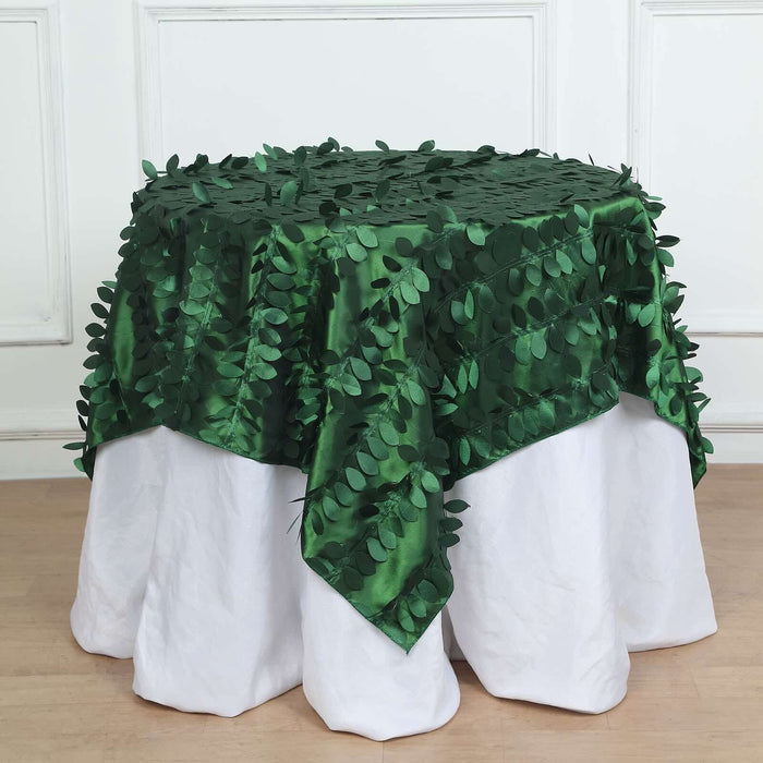 Green leaf-patterned tablecloth draping over a white table.