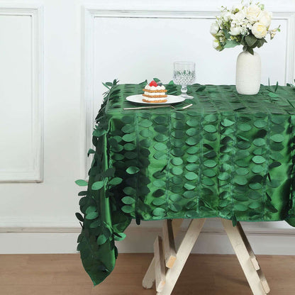 Green leaf-patterned tablecloth on a wooden table with dessert and flowers.