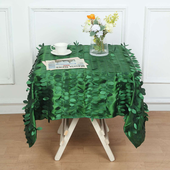 Green leaf-patterned tablecloth draped over a table with flowers and a tea set.