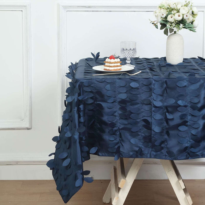 Navy tablecloth with leaf design on a styled table setting with dessert and flowers.